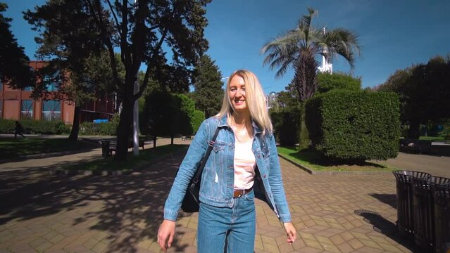 Shooting in first person, young beautiful blonde takes guy by hand and runs around city, through park on sunny day. woman in denim suit, girl. camera follows him. Travel enthusiasts. couple in love.