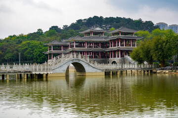 Fototapeta na wymiar Chinese style pedestrian stone arch bridge over lake in park