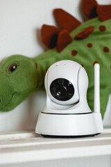 IP camera on the shelf with toys, serving as baby monitor