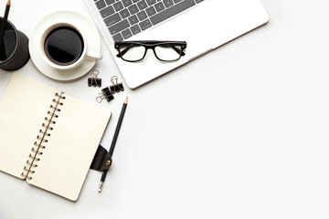 Flat lay, top view office table desk. Workspace with blank Laptop, office supplies, pencil, green leaf, and coffee cup on white background.