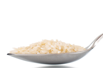 Uncooked organic rice with a metal spoon, close-up, isolated on a white background.