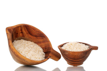 Uncooked organic rice in two wooden cups, close-up, isolated on a white background.