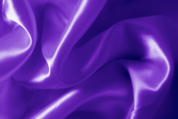 The texture of the proton purple cloth with waves and shrugs. Shiny fabric.