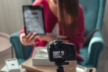 Naklejka premium Close-up camera screen, woman blogger makes video of unpacking gadgets at home