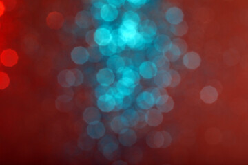 Blur sparkles. Defocused red and blue color gradient shiny grain texture on dark background. Bokeh...