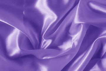 The texture of the proton purple cloth with waves and shrugs. Shiny fabric.