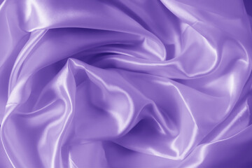 The texture of the proton purple cloth with waves and shrugs. Shiny fabric.
