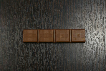 a small bar of milk chocolate on a brown table