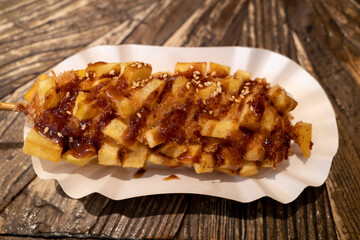 Korean style hotdog, Korean street food, hotdog with Fried potatoes topping, on wooden table.