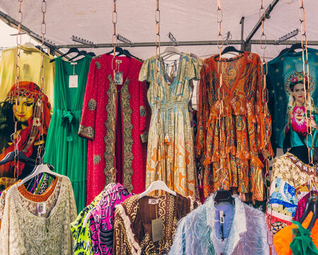 ropa de mujer de segunda mano barata en venta de garaje, ropa colgada en un estante en un mercado de pulgas, moda vintage en el mercado de ropa