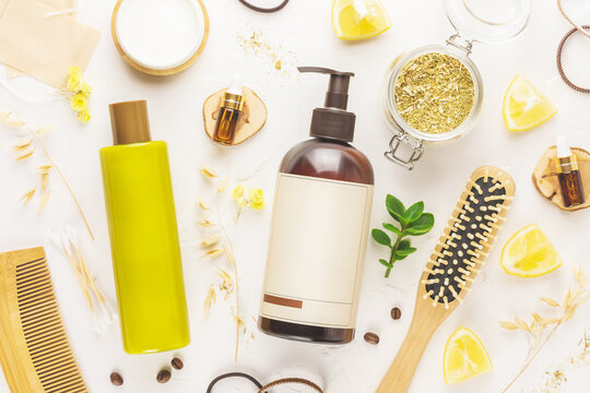 Hair cosmetics. Hair care card with shampoo and conditioner bottles with combs, mask for hair, oil, lemon and herbs on white background. Soft image style. Mock up of natural beauty products for hair