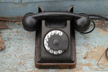 Old black retro phone on a wooden table, rotary phone