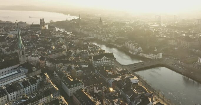 Wide Establishing Aerial Shot of Zurich City Center Landmark flythrough River Limmat at Sunrise or Sunset. Amazing Drone Footage of Switzerland Cityscape Riverside Aerial panorama.
