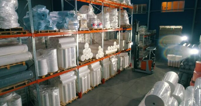 The forklift puts the goods on the shelf of the warehouse. The forklift puts the nonwovens on the shelf of the factory warehouse. Warehouse at the nonwovens factory.