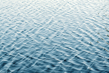 Water surface with ripples and sunlight reflections