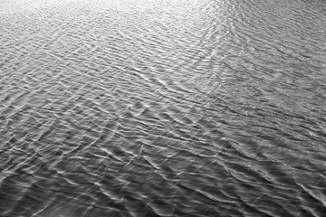 Water surface with ripples and sunlight reflections