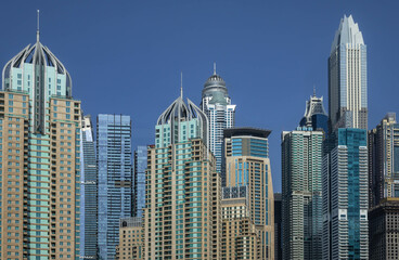 Futuristic skyscrapers of Dubai Marina against the blue sky