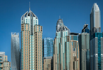 Fototapeta na wymiar Futuristic skyscrapers of Dubai Marina against the blue sky