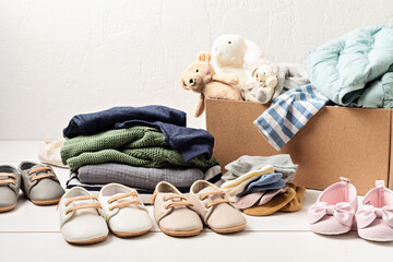 Baby and child clothes, toys in box. Second hand apparel idea. Circular fashion, donation, charity...