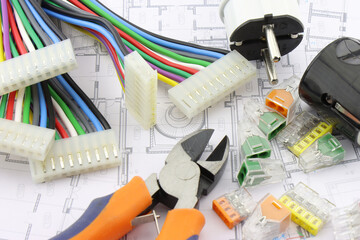 Tools for electrical installation on a close-up schematic diagram.