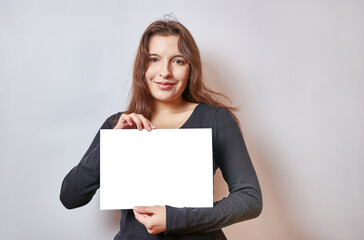 Naklejka premium Pretty girl holding a banner, white billboard.