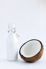 Bottle of coconut milk and coconut on a white background. Healthy food concept, gluten free diet.
