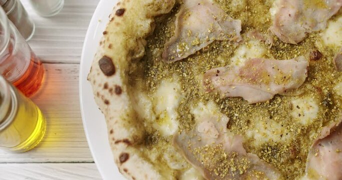 Pizza with Meat and Pesto, Cheese Parmesan fresh out of the oven ready to eat. Delicious Italian pizza. Napoli Pizza. Food Service on white table and ingredient. Tasty Pizza with Cheese and Parmesan.