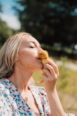 A young woman kisses a little yellow duckling