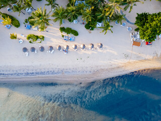 drone view at a beach from above in Mauritius, drone view with umbrella and sunbed on the beach.