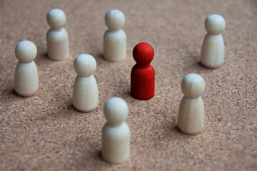 Red wooden doll figure surrounded by other doll figure. Harassment concept