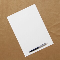 Template of white paper with pen lies diagonally on light brown cloth background. Concept of business plan and strategy. Stock photo with empty space for text and design.