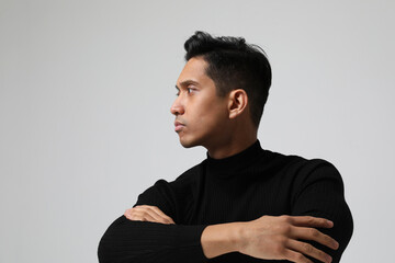 Obraz premium Serious Asian young man posing near white wall. Concept of businessman. Mock up.