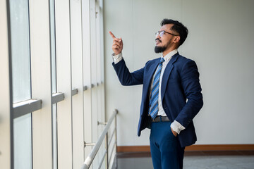 young businessman standing by the window