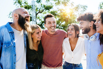 Group of smiling young friends having fun together outdoors - Multiracial millennial people...