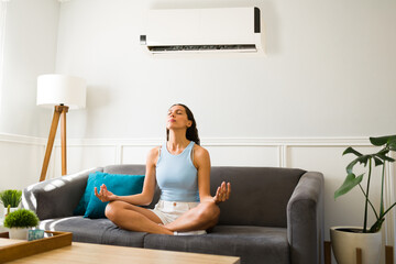 Latin woman doing a meditation with the ac on - obrazy, fototapety, plakaty