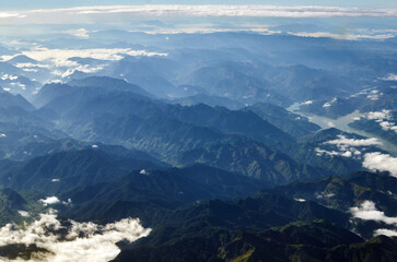 view from the plane to the beautiful low mountains with white clouds