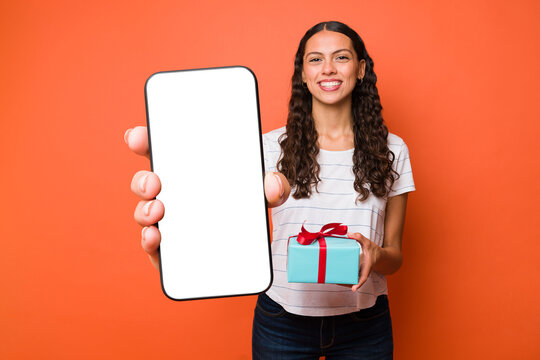 Young woman with a gift showing her phone screen