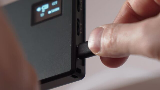 Hand holding USB type C cables to connect or disconnect. Selective focus