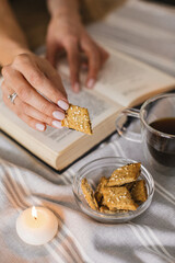 Still life with a Cup of coffee, cookies, candles and a book. The atmosphere of a cozy morning Breakfast at home or in a cafe.