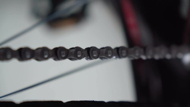 Cleaning bicycle chain with cloth. Regular, common bike maintenance at home, close up, details. Selective focus