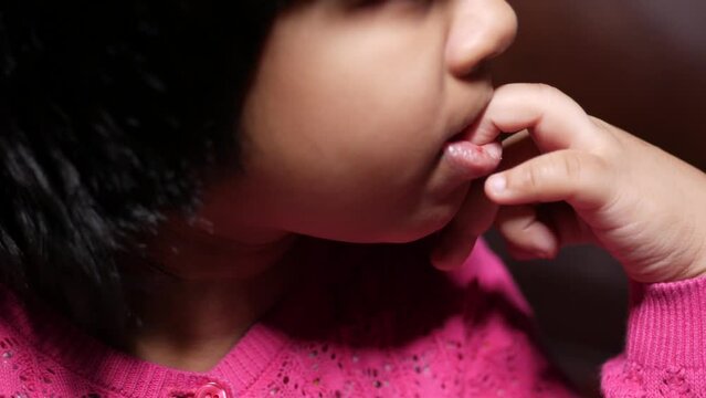  child girl biting her nails at home,