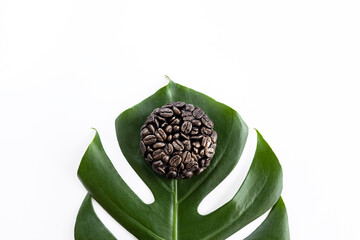 Close-up coffee soap face scrub and monstera leaf on white background. Natural exfoliation for body care. Selective focus, top view