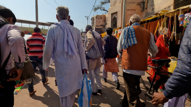 Holy Places near the river ; People walking in the streets of rural market
