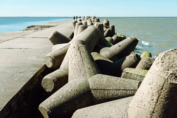 The Northern Breakwater in Liepaja, a close-up of tetrapods and splashing, splattering waves. Dolosse structure in the Baltic sea.