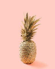 Pineapple in gold isolated on pink pastel background.Minimal fruit summer creative concept.Soft shadow.