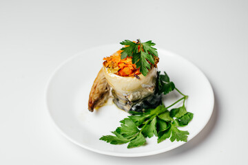 Baked fish on the fire with vegetables and decorated with carrots and greens on a plate