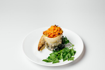 Baked fish on the fire with vegetables and decorated with carrots and greens on a plate