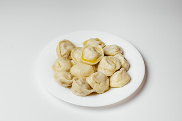 Hot delicious dumplings drizzled with butter in a plate on a white background