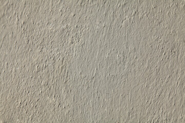 White and uneven wall painted with whitening, texture, background. An old building wall, painted with whiting. Wavy and bumpy surface in white color, faded in the sun
