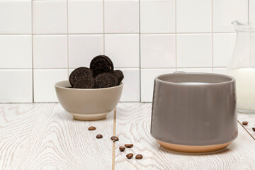 Latte coffee, cacao, cappuccino with milk in gray cup and sweet cookies in bowl on white kitchen tile background, hot beverage and tasty dessert food close up.mockup, template